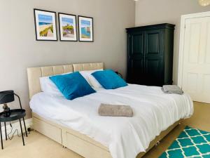 a bedroom with a large white bed with blue pillows at Lovely Westbourne apartment - 15 min walk to beach in Bournemouth