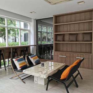 a living room with a table and chairs at Elements Srinakarin in Ban Khlong Prawet
