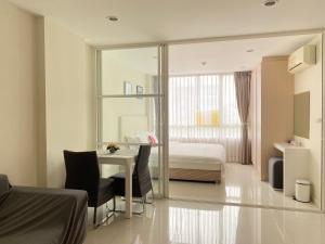 a bedroom with a bed and a desk and a table at Elements Srinakarin in Ban Khlong Prawet