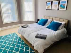a bedroom with a large bed with blue pillows at Lovely Westbourne apartment - 15 min walk to beach in Bournemouth