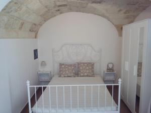 a bedroom with a white bed with a white headboard at House Rental for Tourists in Monopoli