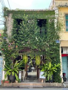 une entrée à un bâtiment couvert de plantes dans l'établissement The Opposite Place, à Malacca