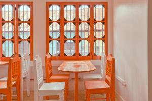 a dining room with a table and chairs and windows at Macarena Hostel in Flores