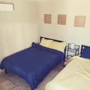 a bedroom with two beds with blue comforter at Baja's Rest Stop in San Felipe