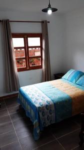 Schlafzimmer mit einem Bett und einem Fenster in der Unterkunft EcoCasa Romantica vista a Cali disfruta en pareja o familia in Yumbo