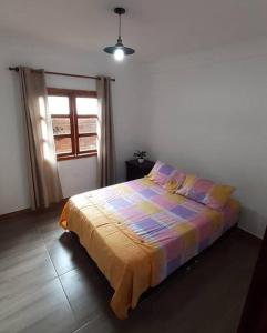 ein Schlafzimmer mit einem Bett mit einer bunten Decke in der Unterkunft EcoCasa Romantica vista a Cali disfruta en pareja o familia in Yumbo