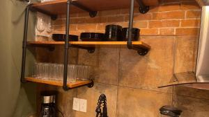 a kitchen with wooden shelves on a brick wall at INDUSTRIAL.SMART HOME in Mérida