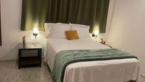 a bedroom with a large white bed with a green blanket at INDUSTRIAL.SMART HOME in Mérida