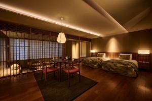 京都市にあるTHE HIRAMATSU 京都のベッド2台、テーブル、ダイニングルームが備わる客室です。