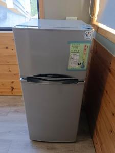 a small white refrigerator sitting in a kitchen at 峰樹屋 in Hengchun South Gate