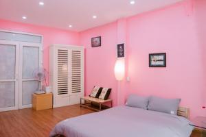 Dormitorio rosa con cama y lámpara en Kim's Homestay Center of Ha Noi en Hanói