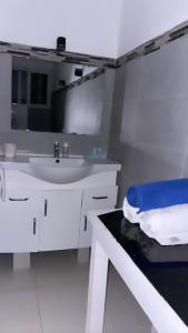 a white bathroom with a sink and a mirror at Villa Brise de Mer in Las Terrenas