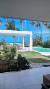 拉斯特拉納斯的住宿－Villa Brise de Mer，享有带游泳池和棕榈树的度假村的景致