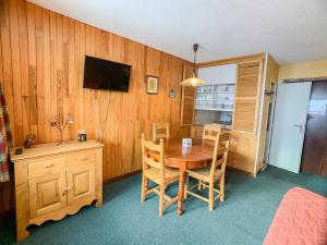 jadalnia ze stołem, krzesłami i telewizorem w obiekcie Appartement cosy · Proche pistes et commerces · Balcon · 6 couchages - FR-1-502-501 w mieście Tignes