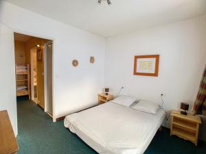 sypialnia z białym łóżkiem i dwiema poduszkami w obiekcie Appartement cosy · Proche pistes et commerces · Balcon · 6 couchages - FR-1-502-501 w mieście Tignes