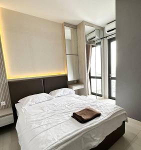 a bedroom with a large bed with a towel on it at One Residence Apartment 2BR near Ferry Terminal in Batam Center