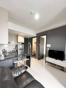 a living room with a couch and a kitchen at One Residence Apartment 2BR near Ferry Terminal in Batam Center