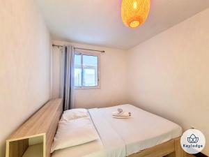 a small bedroom with a bed and a window at Kheyl Home 2 étoiles - T3 de 47 m2 à Saint-Denis in Saint-Denis