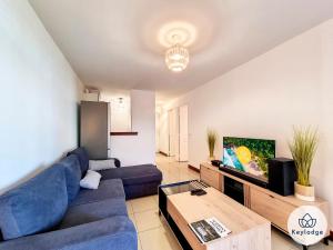 - un salon avec un canapé bleu et une table dans l'établissement Kheyl Home 2 étoiles - T3 de 47 m2 à Saint-Denis, à Saint-Denis