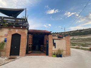 una casa di mattoni con una porta nera su una strada di Casa Rural Alfoz, -Tiny house- con patio privado, barbacoa, wifi, netflix, Aire acondicionado a Velliza