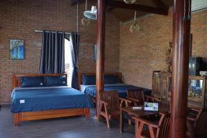 sypialnia z 2 łóżkami, stołem i krzesłami w obiekcie Homestay Hơ Đơng w mieście Pleiku