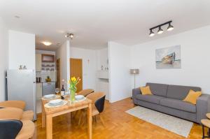 una sala de estar con un sofá y una mesa en Apartment Smile with secure private garage, en Split