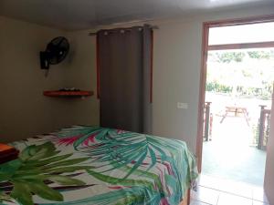 a bedroom with a bed and a sliding glass door at Moorea Vaiare Lodge in Moorea