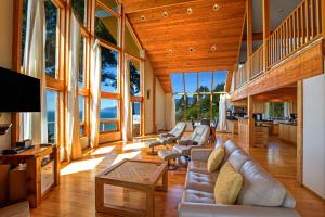 un soggiorno con divano, sedie e finestre di Gorgeous Oceanview, Hot Tub! Oceanfront! Shelter Cove, CA Tesla EV Station a Shelter Cove