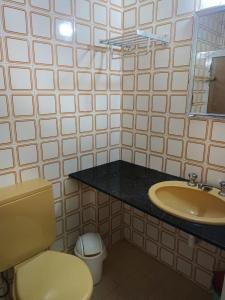 uma casa de banho com um lavatório, um WC e um espelho. em Condomínio Wembley Mar III - APT 114 em Ubatuba