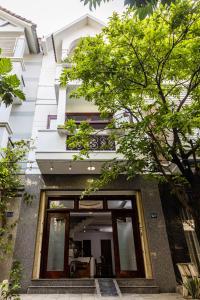 a building with glass doors and trees in front of it at Simple House Near My Khe Beach and Night Street in Da Nang