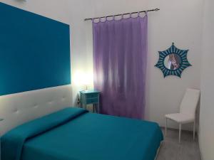 ein Schlafzimmer mit einem blauen Bett und einem lila Vorhang in der Unterkunft Casa Mela in Castelsardo