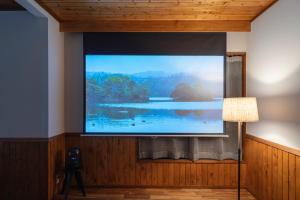 a large flat screen tv on a wall in a room at YAMO-Kawana Ippekiko in Ogi