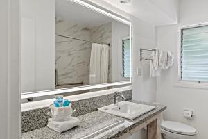 a white bathroom with a sink and a mirror at Ocean Lodge Santa Monica Beach Hotel in Los Angeles