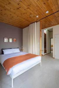 a bedroom with a large bed with a wooden ceiling at YAMO-Kawana Ippekiko in Ogi