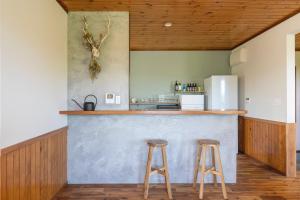 a kitchen with a counter and two stools at YAMO-Kawana Ippekiko in Ogi