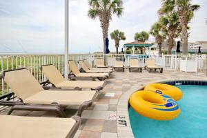 a pool with chaise lounges and a yellow lifesaver at Club Wyndham 521 in Myrtle Beach