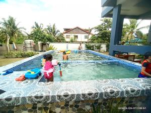 a group of children playing in a swimming pool at Bahai Jujai Resort in Baler