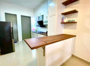 uma cozinha com um balcão de madeira e um frigorífico em Homestay Ika KLIA @ Enstek em Kampong Chinchang