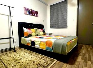 - une chambre avec un lit et une couette colorée dans l'établissement Homestay Ika KLIA @ Enstek, à Kampong Chinchang