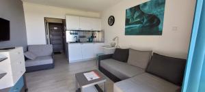 uma pequena sala de estar com um sofá e uma cozinha em Sea Power Horyzont Apartament 25 PICCOLO em Jastrzębia Góra