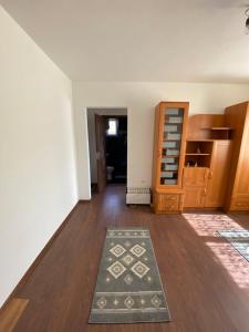 an empty living room with a rug on a wooden floor at Maris in Sângeorz-Băi