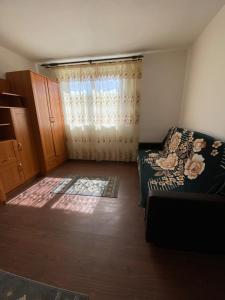 um pequeno quarto com uma cama e uma janela em Maris em Sangeorz-Bai