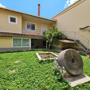 una casa con una statua davanti a un cortile di Billy's Apartment a Ligourio