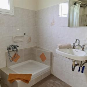 un bagno con lavandino e vasca accanto a un lavandino di Billy's Apartment a Ligourio