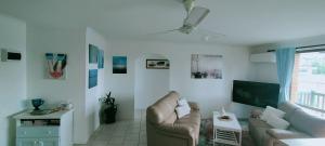 a living room with a couch and a flat screen tv at Mels Place in South West Rocks