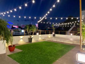 a rooftop patio with lights and a green lawn at Aurora Suites in Manila