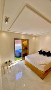 - une chambre avec un grand lit et une grande fenêtre dans l'établissement superbe appartement climat Centralisé avec Jacuzzi supplémentaires, à Kenitra