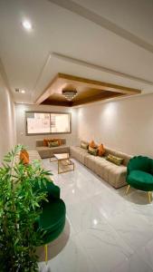- un salon avec un canapé et deux fauteuils verts dans l'établissement superbe appartement climat Centralisé avec Jacuzzi supplémentaires, à Kenitra