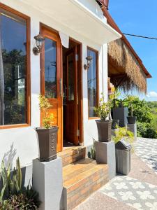 a house with potted plants in front of the door at Penida Hills Hostel in Nusa Penida