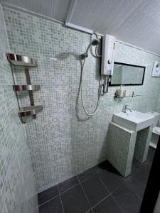 a bathroom with a shower and a sink at Swiss Cottage Tioman in Tioman Island